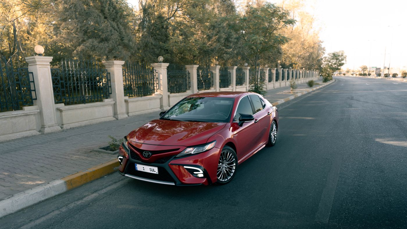 Illustrative photo of a red daily-driver sedan on a tree-lined street